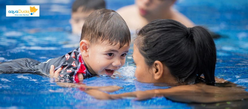 An instructor practicing active supervision with a toddler in a swimming pool to demonstrate essential water safety for kids.