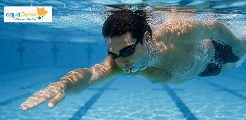 Swimmer exhaling steadily underwater to clear lungs before taking a quick breath at the surface for smooth swimming rhythm