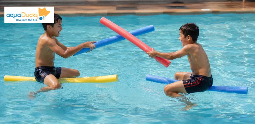 Kids jousting on pool noodles, exploring fun swimming games for kids and exciting swimming pool water games with friends.