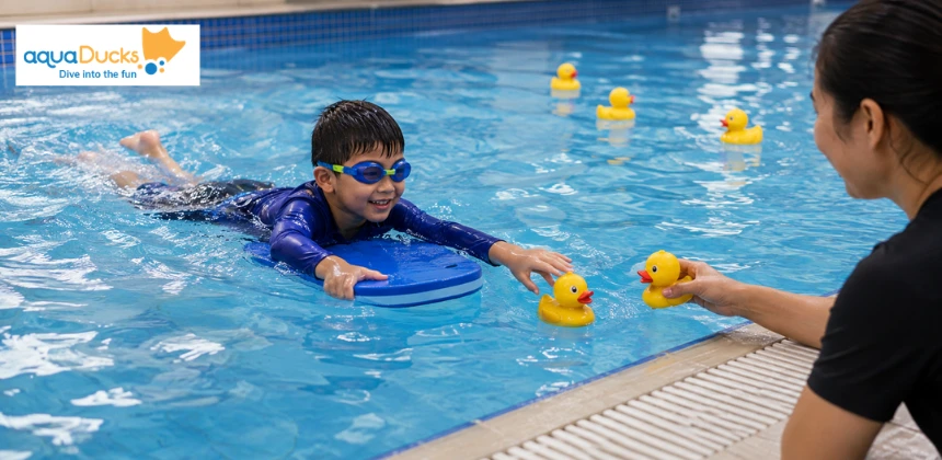 Child rescuing ducks with kickboard, enjoying fun swimming games for kids and exciting swimming pool games with instructor.