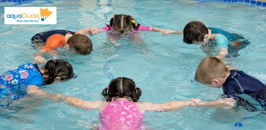 Kids holding hands in a circle enjoying swimming games for toddlers, exploring fun swimming pool water games together.