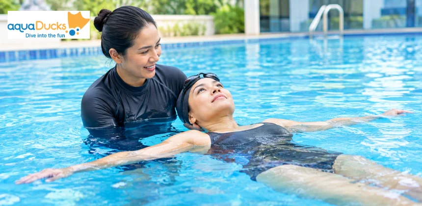 Adult learning to float with a swimming instructor in a pool