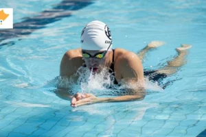 Swimmer performing smooth breaststroke in a calm Singapore swimming pool, demonstrating proper technique