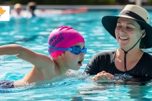 Beginner learning how to swim freestyle with instructor in a pool