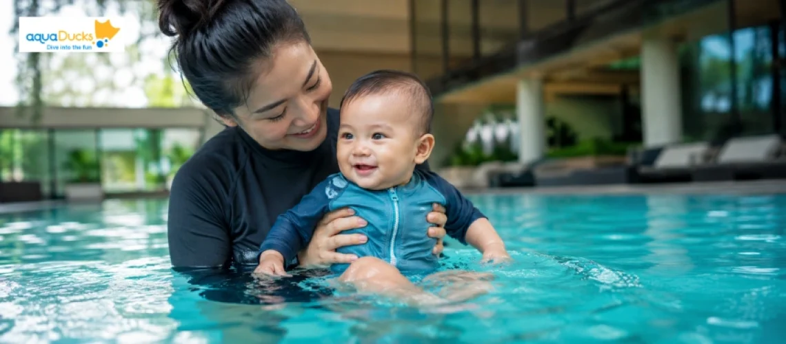 Mother and baby enjoying water, learning what do babies wear swimming safely during a professional baby swim class in Singapore